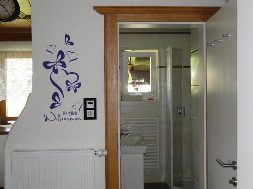 a bathroom with a purple flower decal on the wall at Marie Luise, Landhaus in Reith bei Kitzbühel