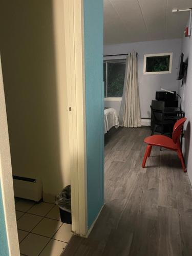 a living room with a red chair and a bedroom at Valued Stay Aloha in Madison