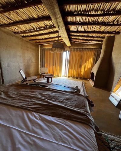 a large room with a large bed in it at Alkamar Camp Agafay in El Karia