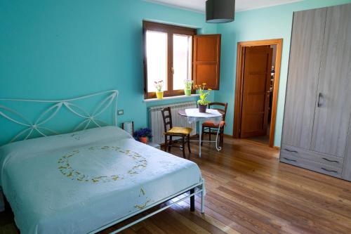 a blue bedroom with a bed and a table at AnimAbruzzo in Cepagatti