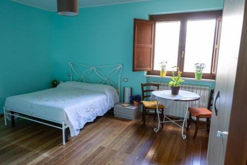 1 dormitorio con cama, mesa y ventana en AnimAbruzzo, en Cepagatti