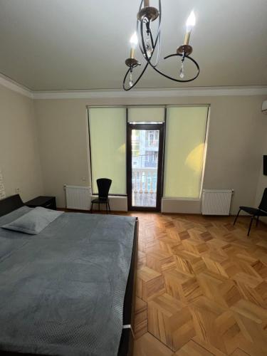 1 dormitorio con cama y lámpara de araña en Smile investments en Tiflis