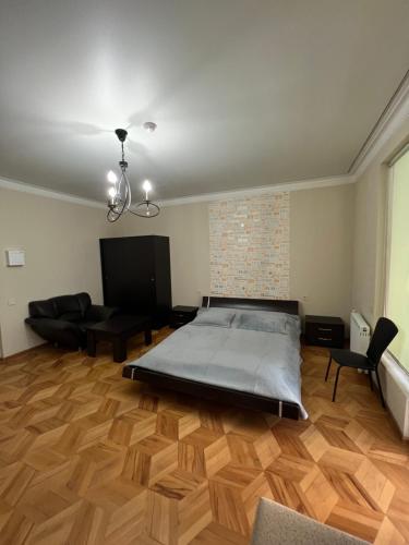 1 dormitorio grande con 1 cama y 1 sofá en Smile investments en Tiflis