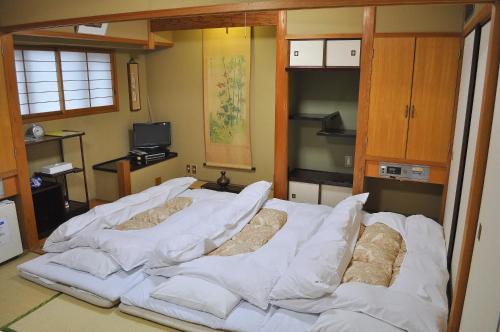 a large bed with white sheets in a room at Hotel Los Inn Kochi in Kochi
