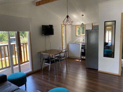 a kitchen and dining room with a table and chairs at Cabañas Mahuida in Villarrica