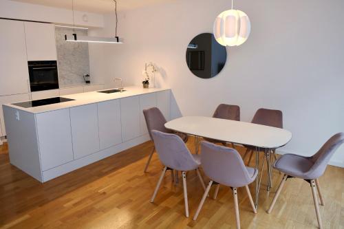 a kitchen with a white table and chairs at Scandi-Hygge 2 bedroom apartment in charming Christianshavn in Copenhagen