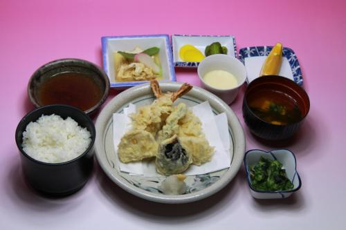 a table topped with a plate of food with rice at Hotel Los Inn Kochi in Kochi