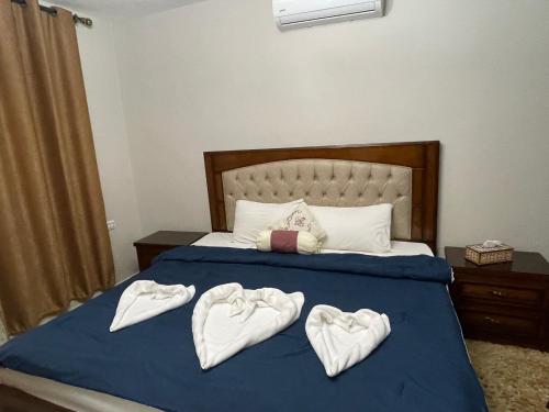 a bed with three towels in the shape of hearts at Cozy House in Wadi Musa