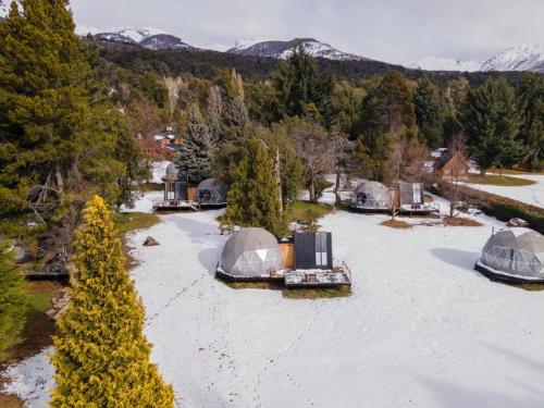 una vista aérea de tiendas de campaña en un patio cubierto de nieve en Glamping Vulcanche en Villa Traful