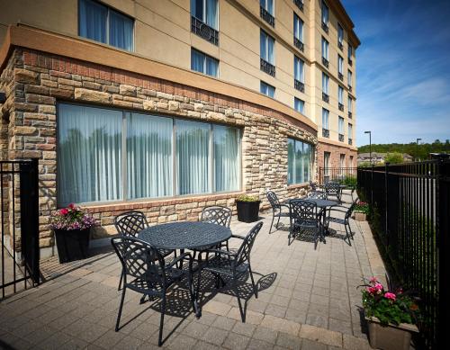 a patio with tables and chairs in front of a building at Holiday Inn Express & Suites Huntsville by IHG in Huntsville