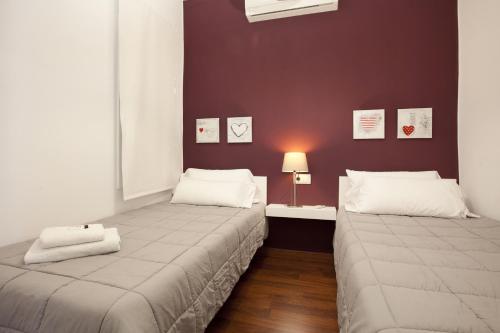 2 camas en una habitación con una pared con fotografías en Alcam Enamorats, en Barcelona