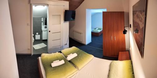a living room with a bed and a bathroom at U Gumisia in Korbielów