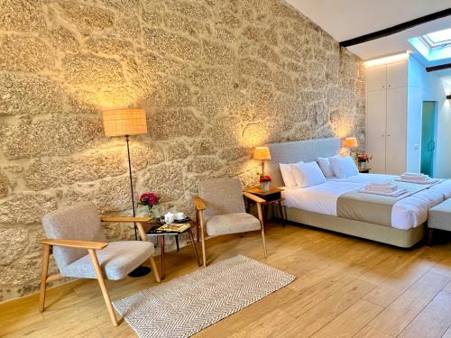 a bedroom with a bed and a stone wall at Quinta da Porta - Solar de Vale de Prazeres in Vale de Prazeres