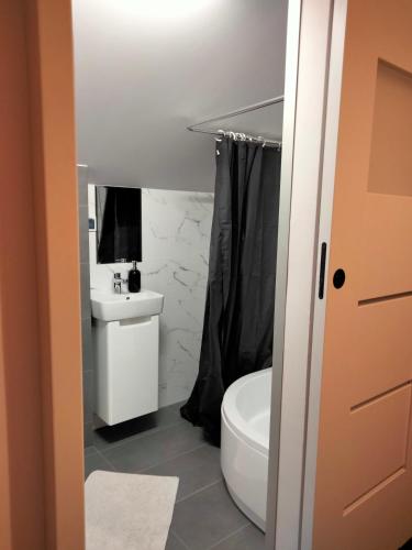 a bathroom with a white toilet and a sink at U Gumisia in Korbielów