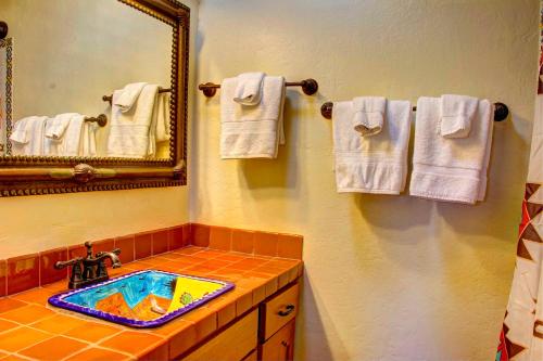 y baño con lavabo, espejo y toallas. en Beautiful Santa Fe residence blocks from the plaza and close to ski basin, en Santa Fe