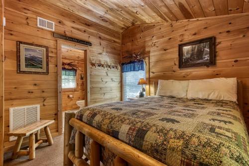 a bedroom with a bed in a log cabin at MYSTIC MOUNTAIN - GREAT LOCATION! CLOSE TO ALL THE ACTION! cabin in Pigeon Forge
