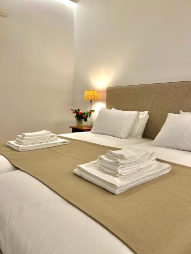 two beds with white sheets and towels on them at Quinta da Porta - Solar de Vale de Prazeres in Vale de Prazeres