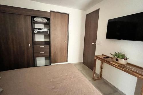a living room with a flat screen tv and a door at Apartamento Hospicio Cabañas in Guadalajara