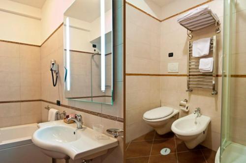 a bathroom with a sink and a toilet and a mirror at Villa Icidia in Frascati