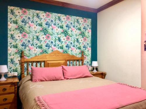 a bedroom with a bed with a floral wallpaper at Apartamentos Islas Canarias in Icod de los Vinos
