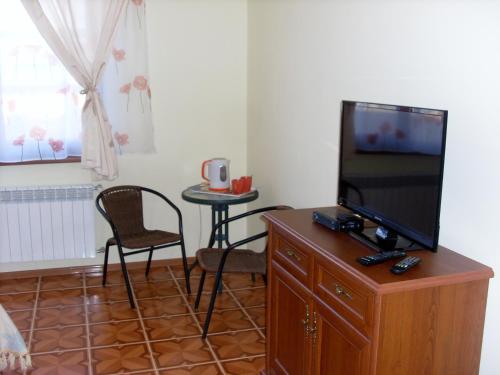 a living room with a flat screen tv on a wooden cabinet at Villa Eden DeLux in Yanoshi