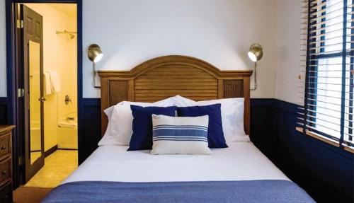 a bedroom with a bed with blue and white pillows at Wylder Hotel - Tilghman Island in Saint Michaels