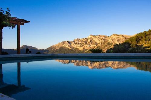 una piscina de agua con montañas en el fondo en Rural ca´s Pelut, en Tàrbena