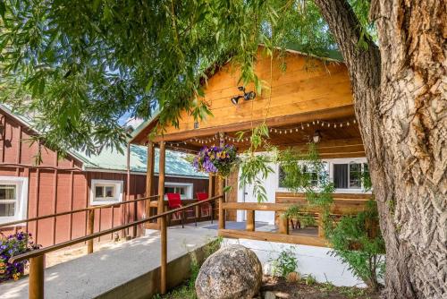 una casa con una terraza con un árbol en Log Cabin Motel en Pinedale