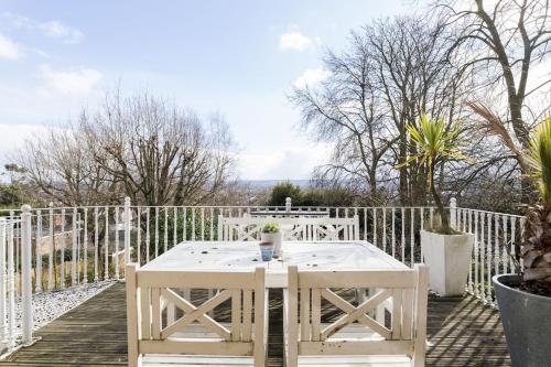 una mesa blanca y sillas en una terraza de madera en High View Large Luxury House, en Norwood