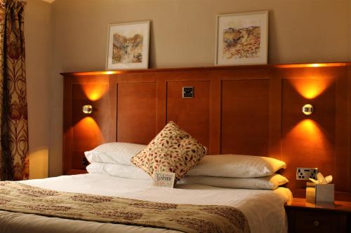 a bedroom with a bed with a wooden headboard at The Oakwheel in Scarborough