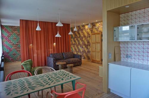 une cuisine et un salon avec une table et des chaises dans l'établissement Kolorowy apartament A9 Katowice Nikiszowiec, à Katowice