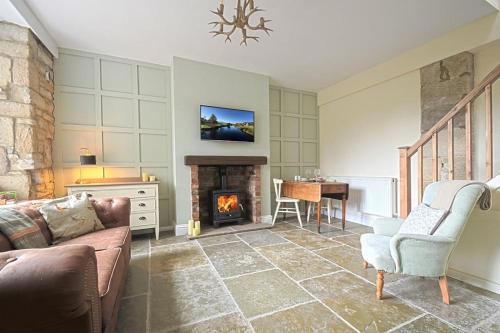 a living room with a couch and a fireplace at Coquetdale Cottage in Rothbury, Nr National Park in Rothbury