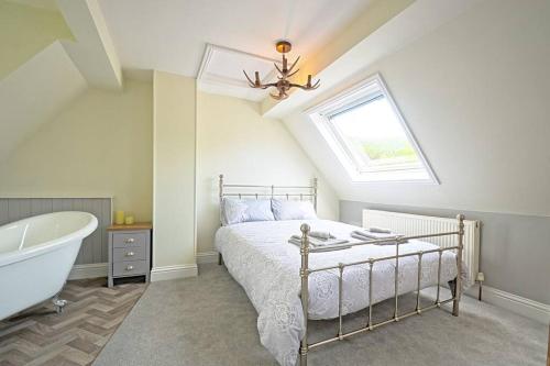 a bedroom with a bed and a bath tub and a window at Coquetdale Cottage in Rothbury, Nr National Park in Rothbury