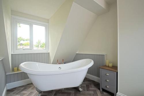a white bath tub in a bathroom with a window at Coquetdale Cottage in Rothbury, Nr National Park in Rothbury
