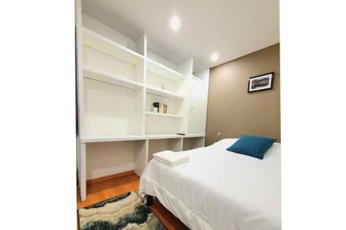 1 dormitorio con cama blanca y estanterías blancas en Habitación privada con TV Polanco Hab 4 en Ciudad de México