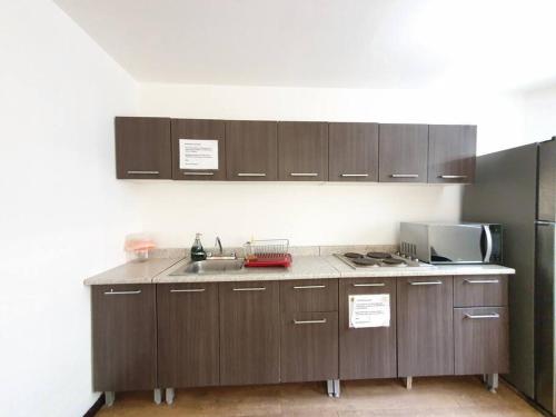 una cocina con armarios de madera y fregadero en Habitación privada con TV Polanco Hab 4, en Ciudad de México