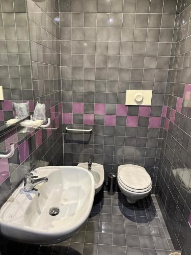 uma casa de banho com um lavatório e um WC em Hotel Comtur em Binasco