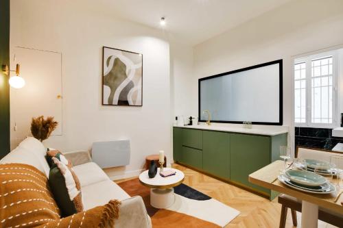 un salon avec un canapé et une télévision à écran plat dans l'établissement Chic Apartment - 1BR-4P - Facing the Louvre, à Paris