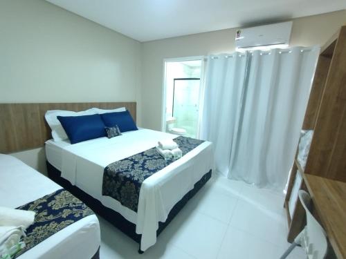 1 dormitorio con 2 camas y almohadas azules en HOTEL LA SIERRA, en Bodoquena