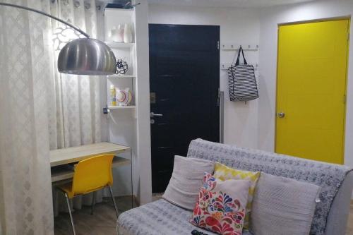 a living room with a couch and a yellow door at Mini independent apartment in Lima