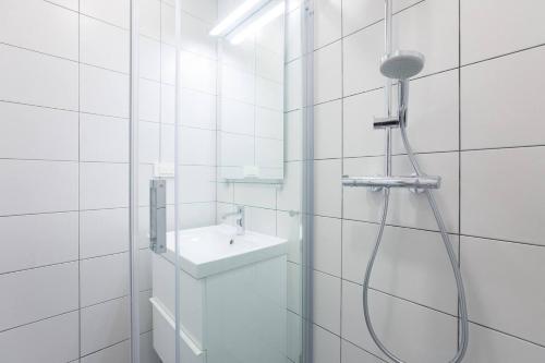 ein weißes Bad mit einer Dusche und einem Waschbecken in der Unterkunft 4gZg Apartment in Zagreb