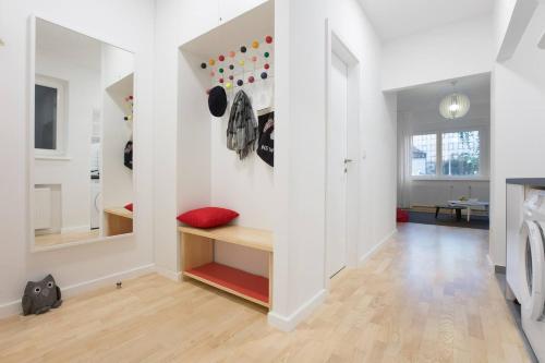 einen Flur mit weißen Wänden und einem roten Kissen auf einer Bank in der Unterkunft 4gZg Apartment in Zagreb