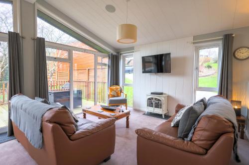 a living room with two couches and a tv at Beautiful Oak Cabin in Devon Finlake Resort Spa in Chudleigh