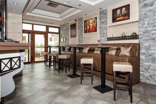 a restaurant with a bar with stools in a room at Bački dvor 