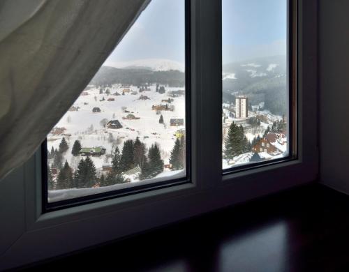 派克波特斯耐茲庫的住宿－Chata Orlik - all inclusive & wellness，窗户享有积雪覆盖的城镇美景