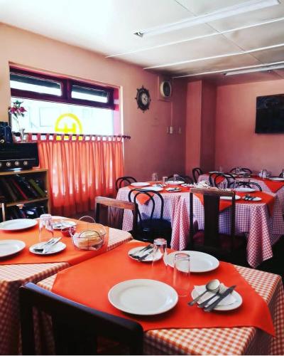 HOTEL NUNA في بويرتو مونت: غرفة طعام مع طاولات مع طاولات حمراء وبيضاء