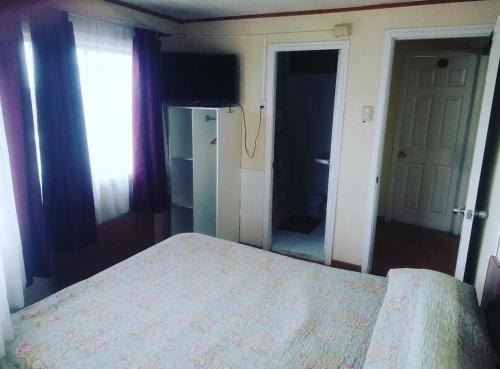 a bedroom with a bed and a window and a mirror at HOTEL NUNA in Puerto Montt