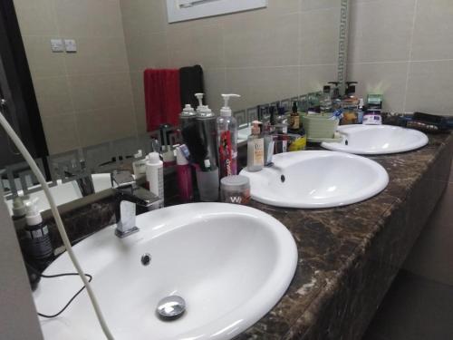 a bathroom counter with two sinks and a mirror at Cheerful 1BR Close to Abu Dhabi Airport and YAS Island in Abu Dhabi