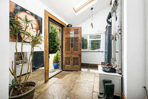 a hallway with a door and a potted plant at Cheerful 7-bedroom house with hot tub sleeps 24 in Iron Acton