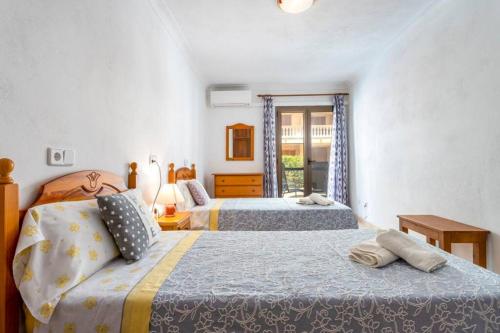 M0 Práctico y Sencillo Apartamento a 100 m de las mejores playas de Mallorca في كولونيا سانت جوردي: غرفة نوم بسريرين ونافذة